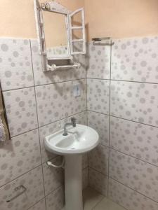 a bathroom with a sink and a mirror at Pousada Recanto dos Arcos in Conservatória