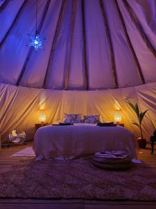 - une chambre avec un lit dans une tente dans l'établissement Goodmuda Tipi's, à Grândola