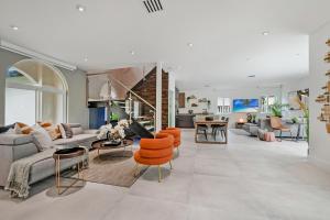 sala de estar de planta abierta con sillas de color naranja y sofá en Glamour Villa - 5BR, Heated Pool, Game Haven L23, en Miami