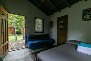 1 dormitorio con 1 cama, 1 silla y 1 ventana en Hostal Campomar, en Santa Verónica