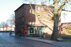 Ein Mann steht vor einem Backsteingebäude. in der Unterkunft Altes Zollhaus Stralsund in Stralsund