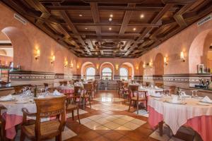 - un restaurant avec des tables et des chaises dans une salle dans l'établissement Hotel Abades Guadix, à Guadix