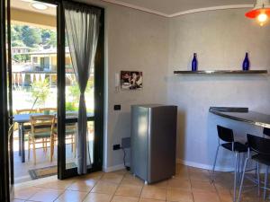 uma cozinha com um frigorífico de aço inoxidável e uma mesa em Casa VistaLago Vertine em Sulzano