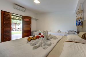 a bed with white socks and fruit on it at Casa Oásis com Sauna, Hidro e Piscina by Carpediem in Aquiraz