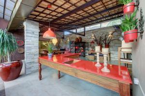 Casa Oásis com Sauna, Hidro e Piscina by Carpediem في أكويراز: مطعم مع منضدة حمراء مع نباتات الفخار