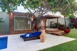 a backyard with a pool and a table and a tree at Casa Oásis com Sauna, Hidro e Piscina by Carpediem in Aquiraz