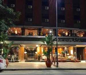 un edificio con un restaurante delante de él por la noche en Garden Plaza en San Miguel de Tucumán