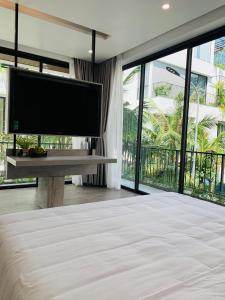 een slaapkamer met een groot scherm en een bed bij Joy Villa Flamingo Đại Lải - 5 phòng ngủ in Phúc Yên