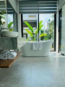 uma casa de banho com banheira e uma grande janela em Joy Villa Flamingo Đại Lải - 5 phòng ngủ em Phúc Yên