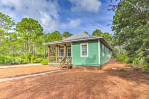 a green tiny house on a dirt lot at Breezy Home with Grills, Pool and Beach Access! in Big Blackjack Landing