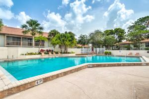 een zwembad voor een gebouw bij Family-Friendly Condo in PGA National Resort! in Palm Beach Gardens