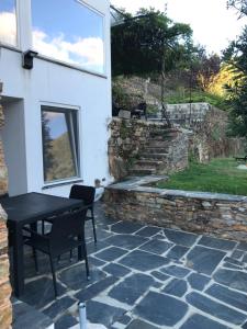 un patio de piedra con mesa negra y silla en Casas do Sinhel, en Chã de Alvares