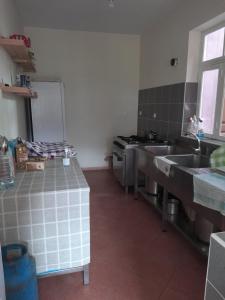 a kitchen with stainless steel sinks and a stove at Pousada Rural Simpatia in Caculi