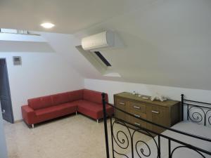 un soggiorno con divano rosso e letto di Szepezd OAK villa a Balatonszepezd