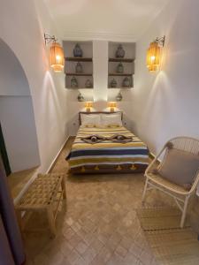 1 dormitorio con cama, silla y luces en Riad Al Karama, en Marrakech