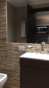 La salle de bains est pourvue d'un lavabo et d'un miroir. dans l'établissement Departamentos Casa del Parque, à Necochea