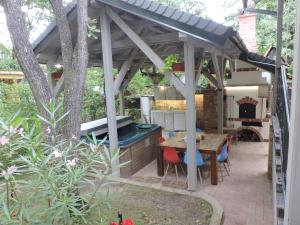 un patio con vasca idromassaggio, tavolo e sedie. di Szepezd OAK villa a Balatonszepezd
