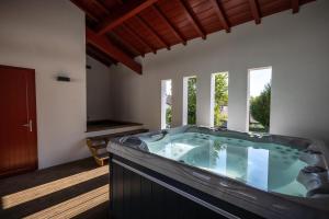 a hot tub in a room with windows at Maison Irriberria in Hasparren