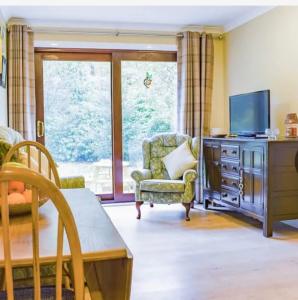a living room with a tv and a couch and a chair at Drummond Neuk - Pets Welcome free, country setting, free onsite parking in Inverness