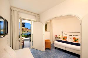a bedroom with a bed and a balcony at Le Calette Bay in Cefalù