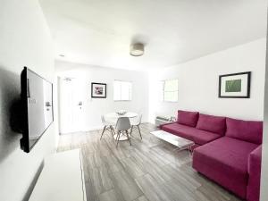een woonkamer met een paarse bank en een tafel bij Beach Gardens in Fort Lauderdale