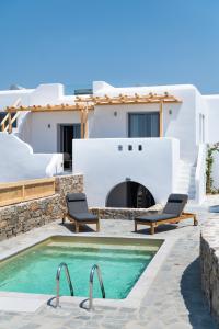 a pool with two chairs next to a house at Mirabelle Luxury Villas in Plaka