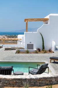 a swimming pool with two chairs and a table at Mirabelle Luxury Villas in Plaka