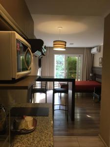 cocina y sala de estar con mesa y sillas en Departamentos Casa del Parque en Necochea
