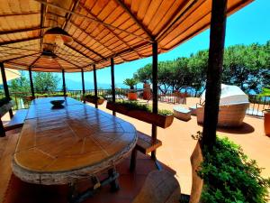 a patio with a wooden table and an umbrella at B&B Iolì Vesuvio in Ercolano +104 photos