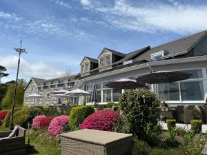 a large building with umbrellas and flowers in front of it at The Moorland Hotel, Haytor, Devon in Haytor