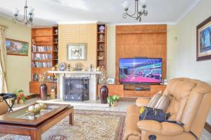 a living room with a fireplace and a television at Mountain Beauty in Mbabane