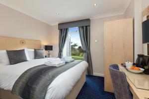 a hotel room with a bed and a desk at The Moorland Hotel, Haytor, Devon in Haytor