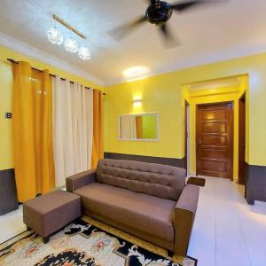 sala de estar con sofá marrón y puerta en Comfy Stay @Permai Puteri Ampang nearby KLCC, IJN, en Ampang
