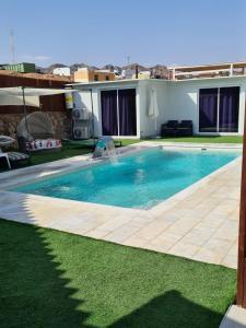 a swimming pool in the backyard of a house at בוילה היפה של יהודית in Eilat