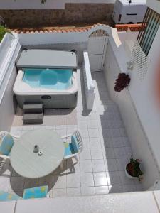 a model of a pool with a table and a tub at Jacuzzi House Sunflower in Costa Del Silencio
