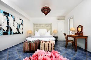 a bedroom with a bed and a table and a desk at Le Calette Bay in Cefalù