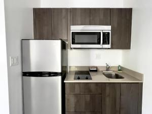 a kitchen with a refrigerator and a microwave at Beach Gardens in Fort Lauderdale