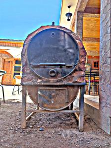 um velho fogão de metal sentado em frente a um edifício em La Tribu del Indio em San Pedro de Atacama