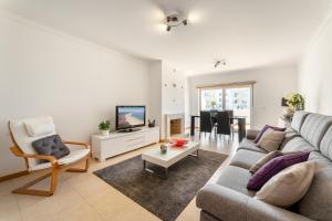 a living room with a couch and a tv at Casa Boa Onda in Nazaré