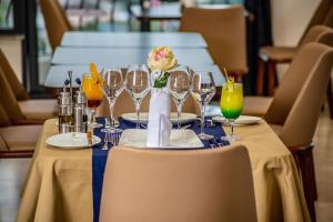 a table with wine glasses and a flower on it at Souaré Premium Hôtel in Conakry