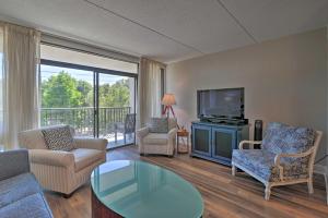 a living room with a couch and a tv at Pawleys Island Condo Retreat with Beach Access! in Pawleys Island