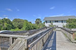 a wooden walkway leading to a white house at Pawleys Island Condo Retreat with Beach Access! in Pawleys Island