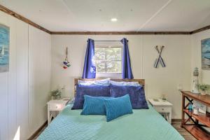 Cozy Lakeside Home with Lake and Mountain Views! في Lakeside: غرفة نوم مع سرير ووسائد زرقاء ونافذة