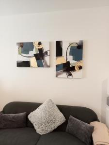 kanapę w salonie z dwoma obrazami na ścianie w obiekcie ART STUDIO Geri w mieście Błagojewgrad