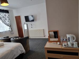 a hotel room with a bed and a desk with a mirror at Casablanca in Blackpool