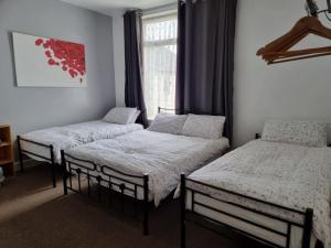 a room with three beds and a window at Casablanca in Blackpool