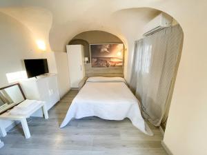 una piccola camera con letto e TV di Monolocale a 50 metri dal mare a Celle Ligure