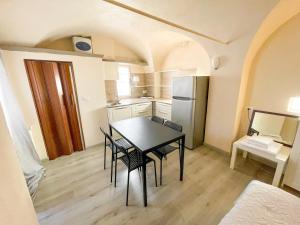 una cucina e una sala da pranzo con tavolo e sedie di Monolocale a 50 metri dal mare a Celle Ligure