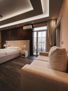 a bedroom with two beds and a couch and a window at Amansar Boutique Hotel in Tirana