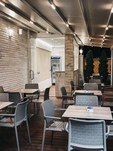 a restaurant with tables and chairs in a room at Amansar Boutique Hotel in Tirana